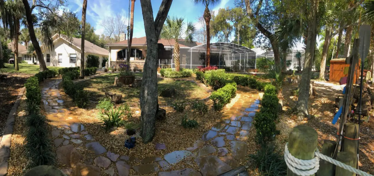 Backyard landscaping with a curved stone path and retaining wall in Central Florida