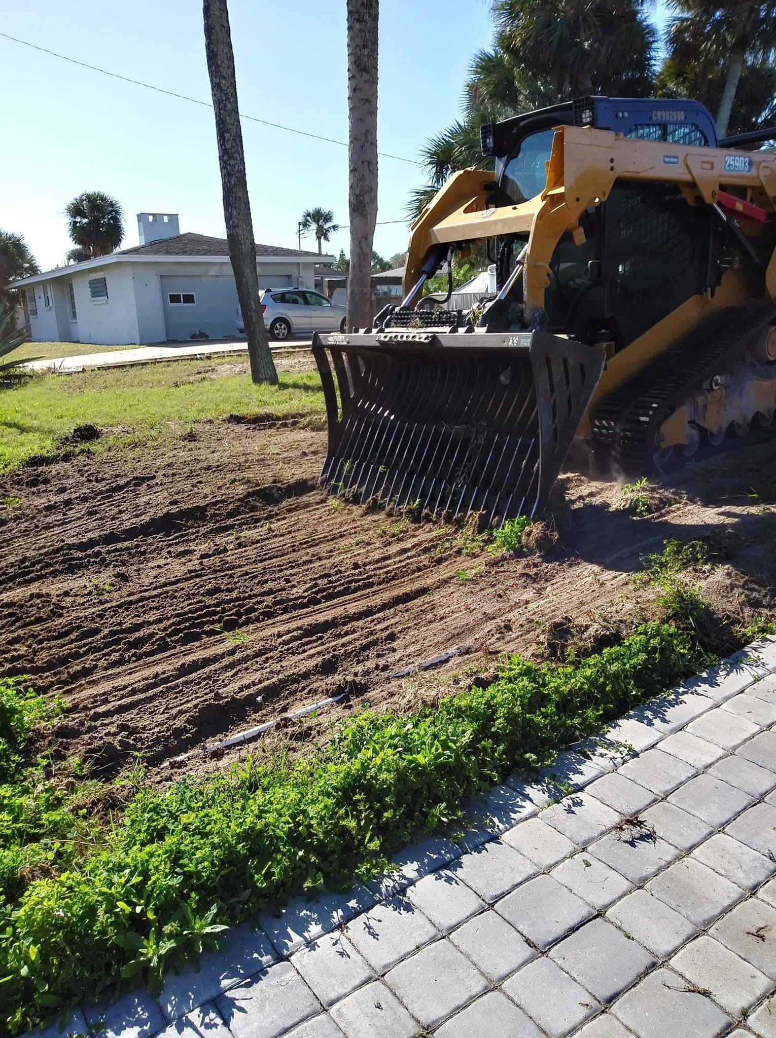 Track loader grading a front yard in Lake Mary FL for spring lawn refresh