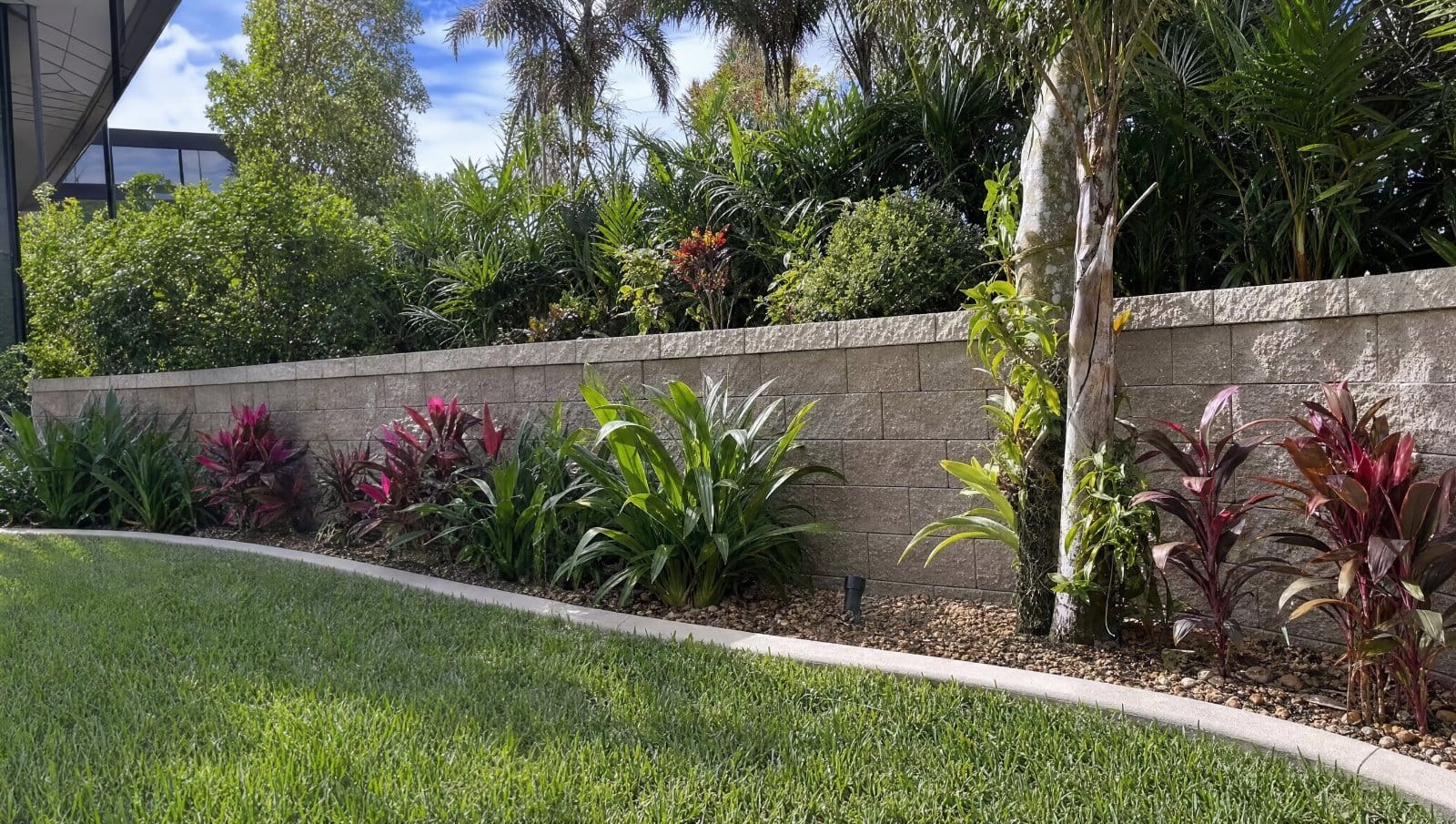 Cinder block retaining wall with landscaping in a Florida backyard