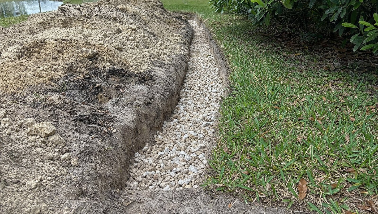 Gravel-filled French drain trench without a pipe in a Florida yard
