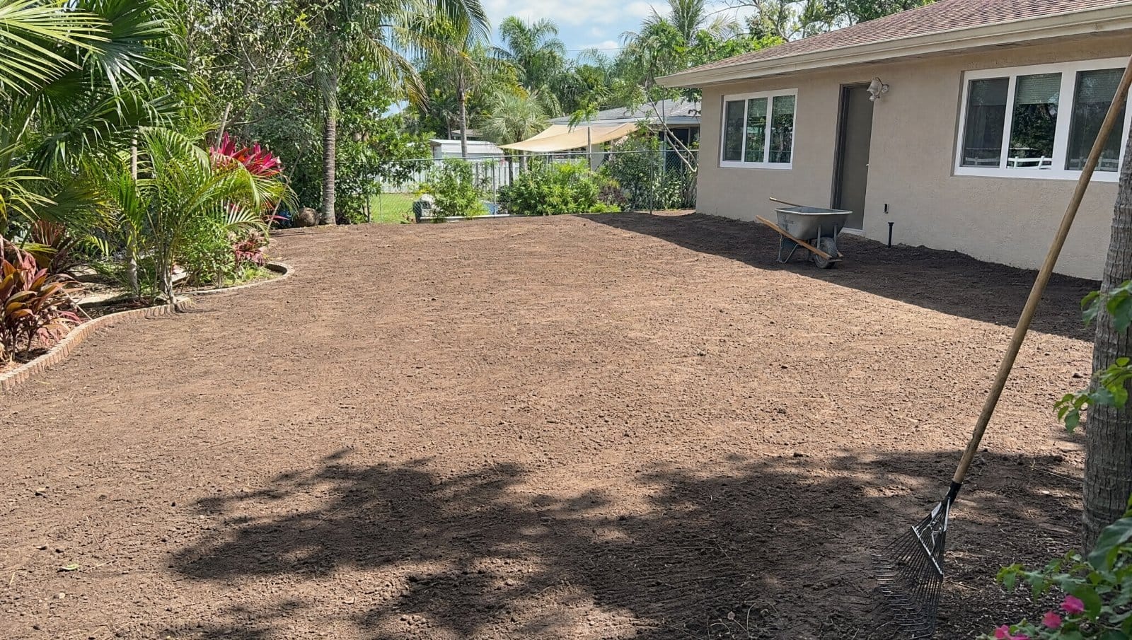 Florida yard being regraded with sloped soil for drainage near a house