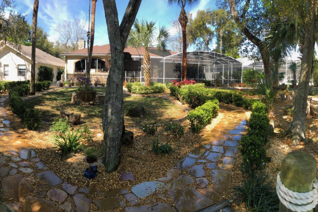 Backyard flagstone garden paths and layered plantings at a Heathrow-area estate — landscaping by DeAngelo's Land Services