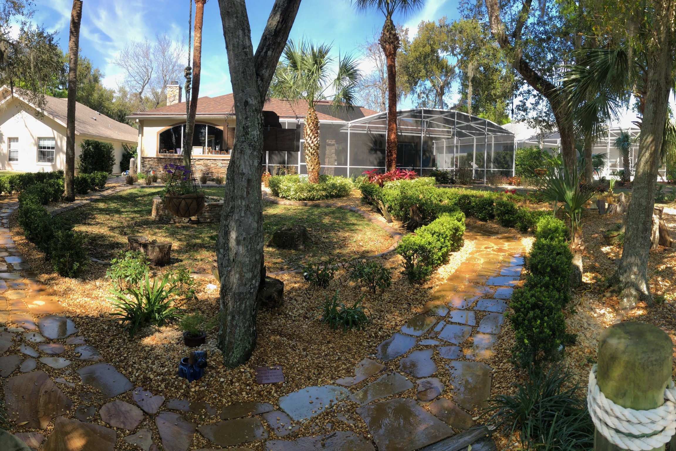Backyard flagstone garden paths and layered plantings at a Heathrow-area estate — landscaping by DeAngelo's Land Services