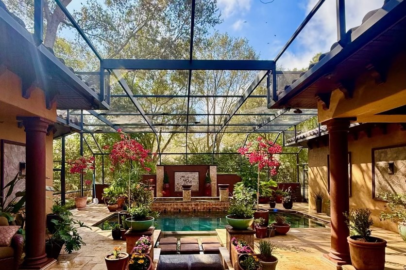 Mediterranean screened courtyard with pool, spa and potted gardens — high-end landscaping in Winter Park, FL by DeAngelo's Land Services